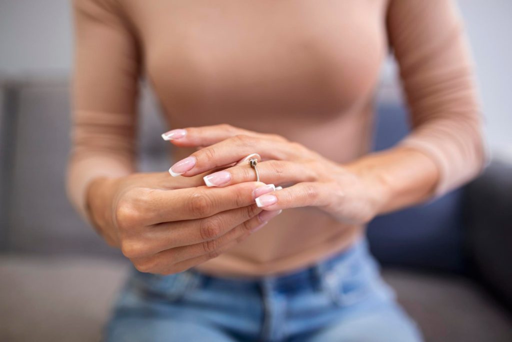 Woman measuring ring size after weight loss using a printable ring sizer