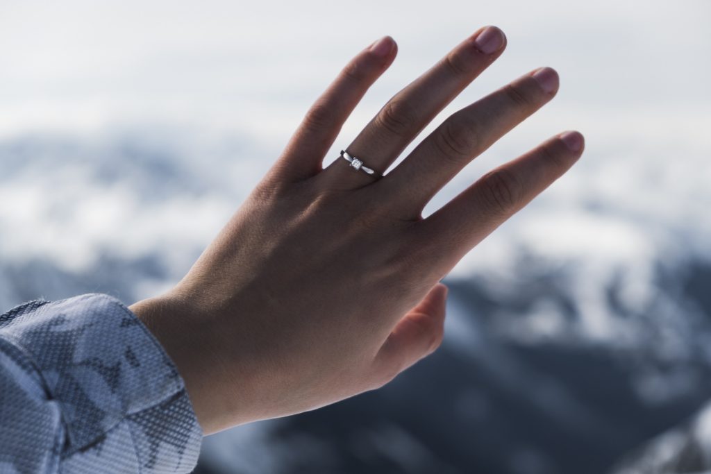 Woman checking ring fit using a ring size chart at home.